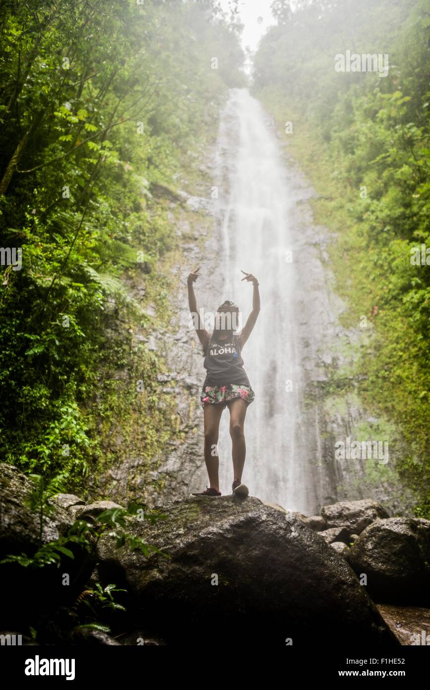 Portrait of young female tourist posing in front of  Manoa Falls, Oahu, Hawaii, USA Stock Photo