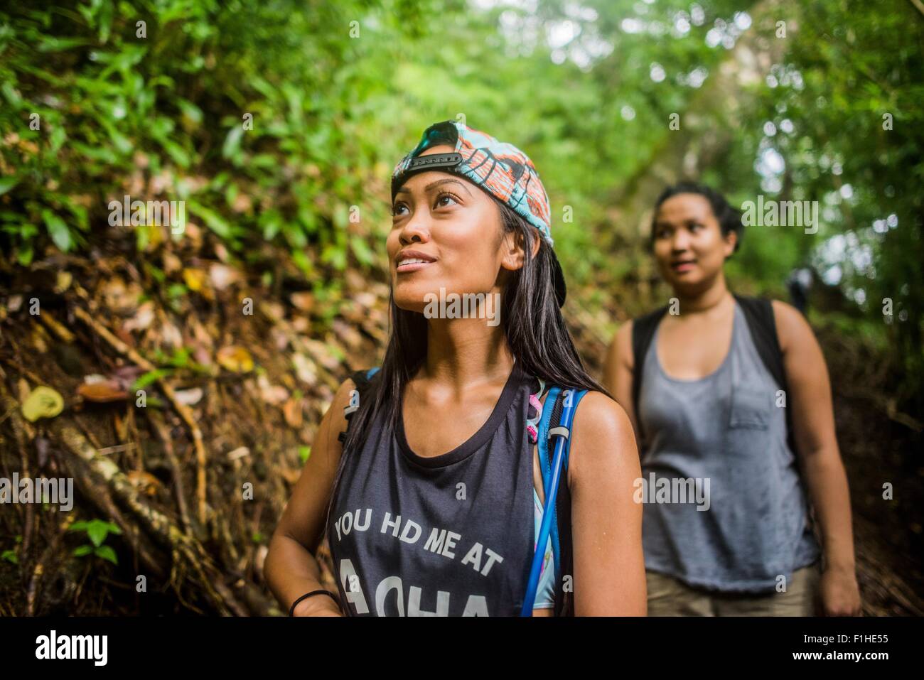 Two young women tourists strolling in jungle at Manoa Falls, Oahu, Hawaii, USA Stock Photo