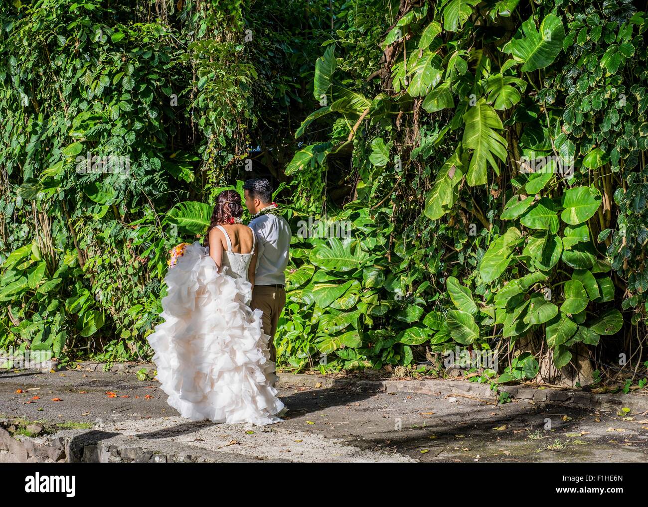 Bride And Bridegroom Strolling In Garden At Hawaiian Wedding
