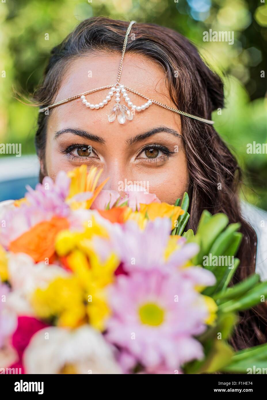 Close up portrait of bride behind colorful boquet at Hawaiian wedding, Kaaawa, Oahu, Hawaii, USA Stock Photo