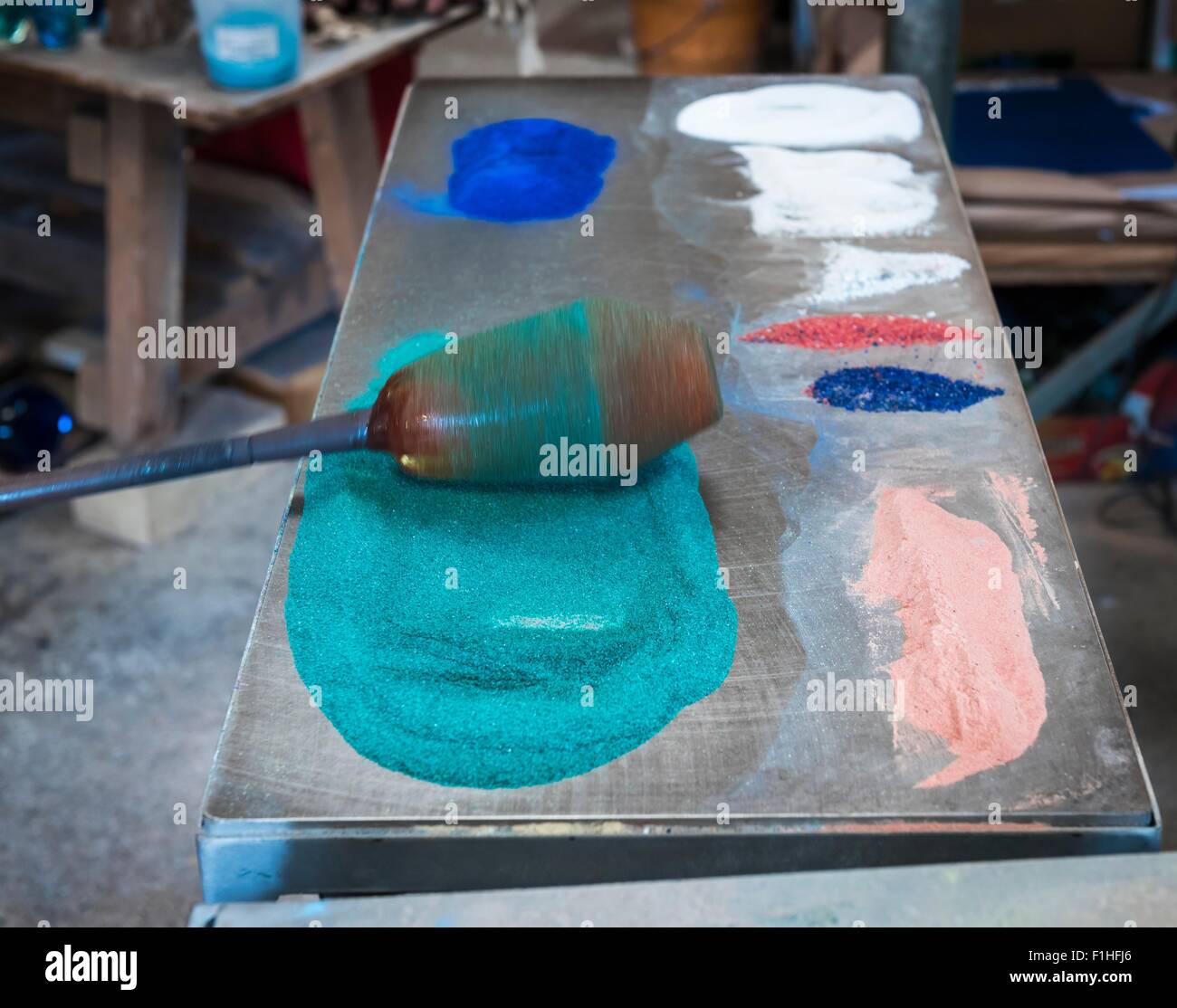 Glassblower adding colour to hot glass Stock Photo