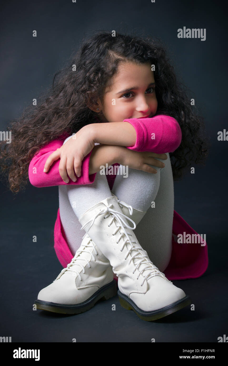 pretty little girl sitting on the floor in white boots Stock Photo Alamy
