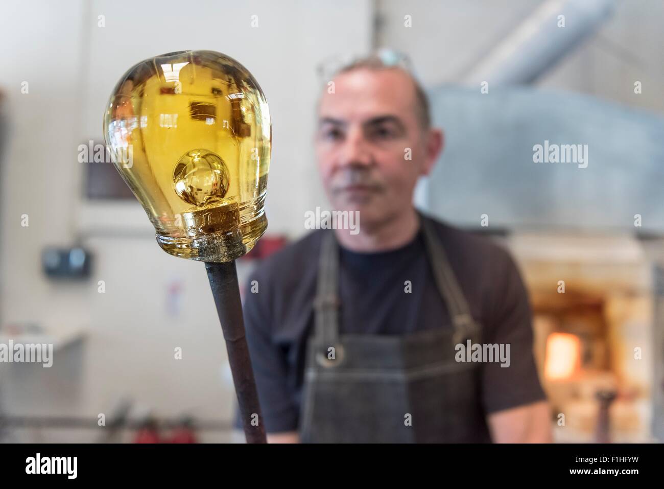 Glassblower with large blob of hot glass Stock Photo
