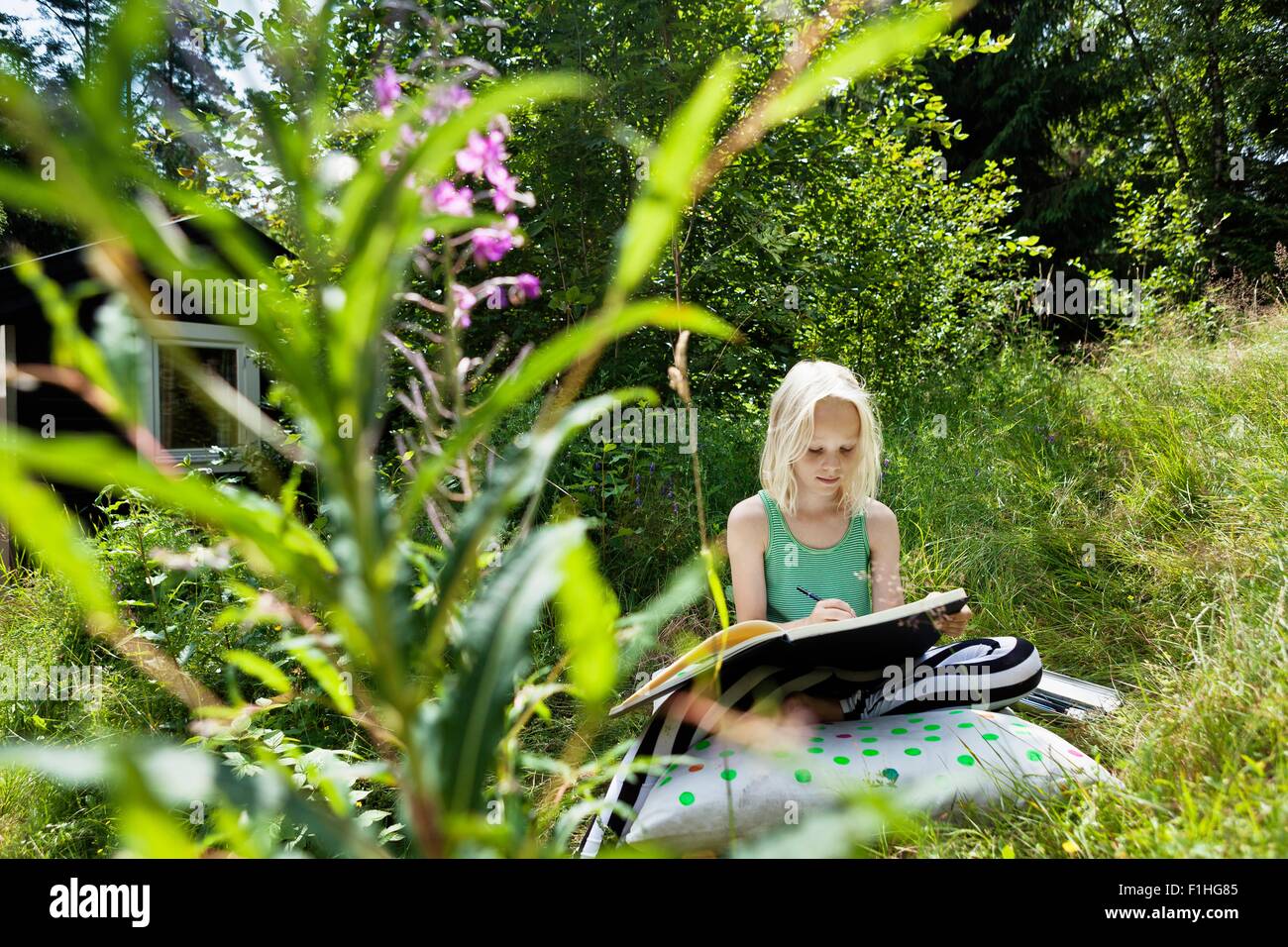 Young girl sitting in rural environment with sketchbook Stock Photo