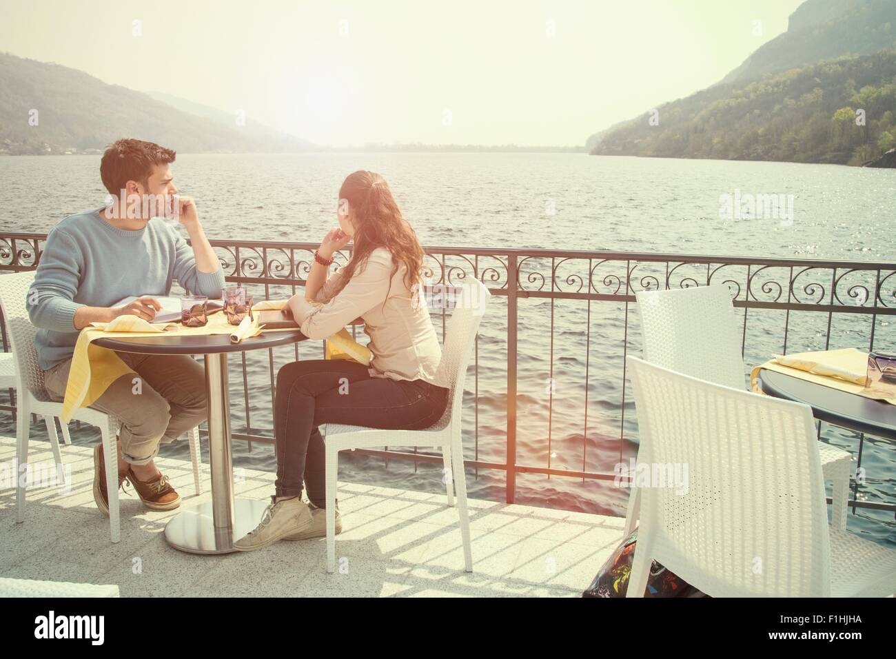 Couple looking out from lakeside restaurant, Lake Mergozzo, Verbania, Piemonte, Italy Stock Photo
