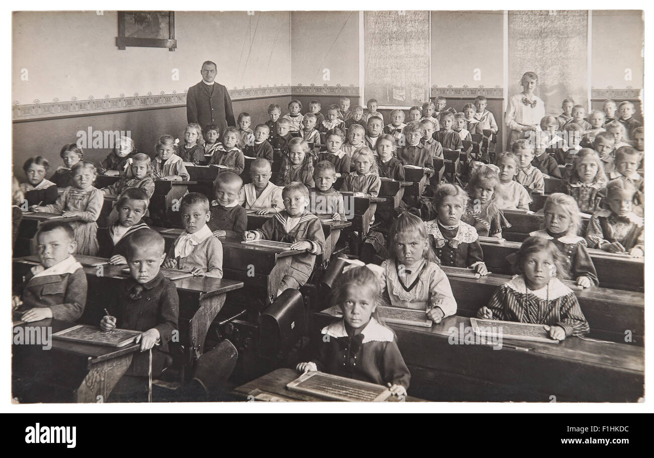 Group of children and teacher in the classroom. Retro picture of classmates in the school. Stock Photo