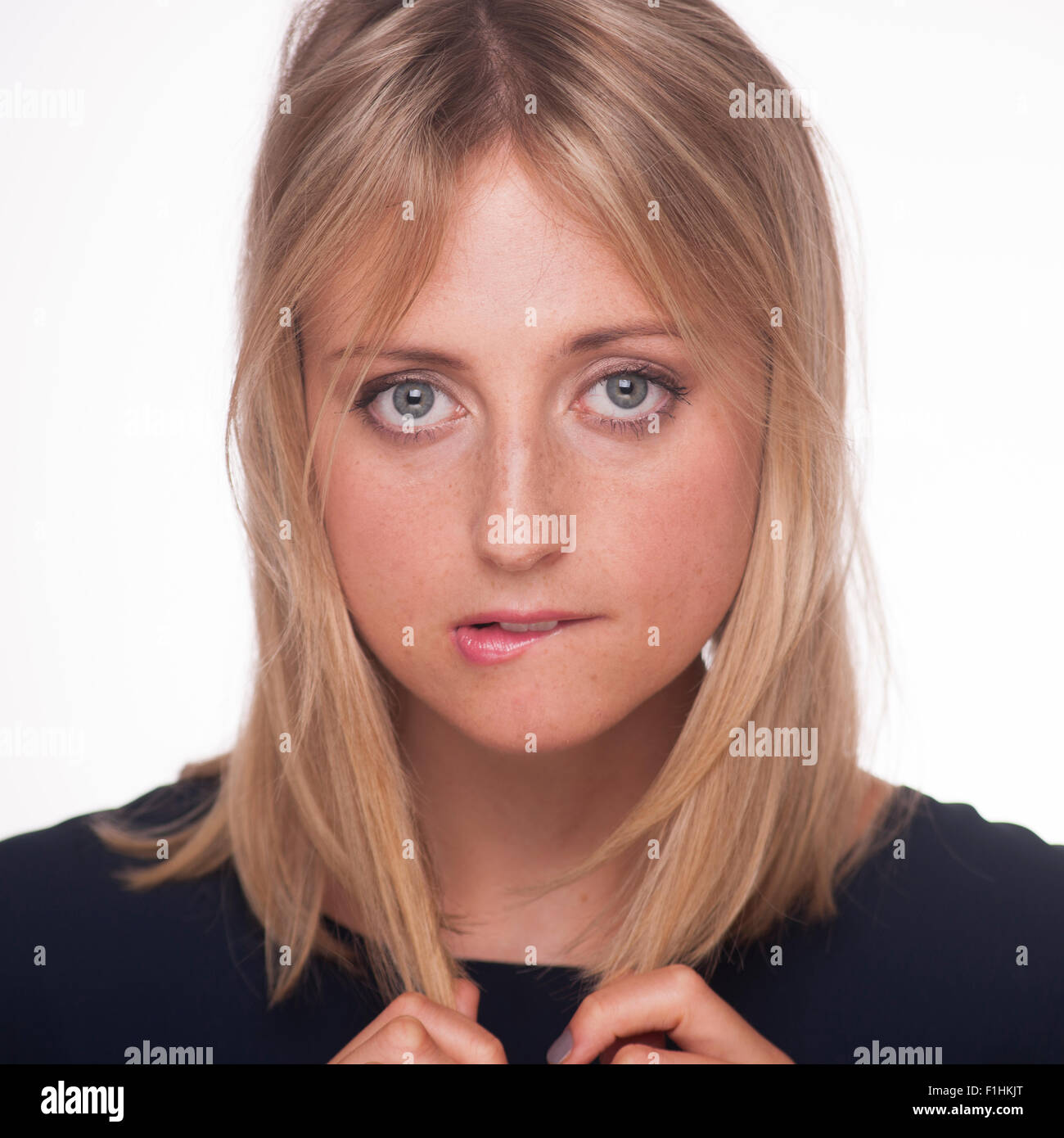 Blonde woman biting her lip Stock Photo - Alamy