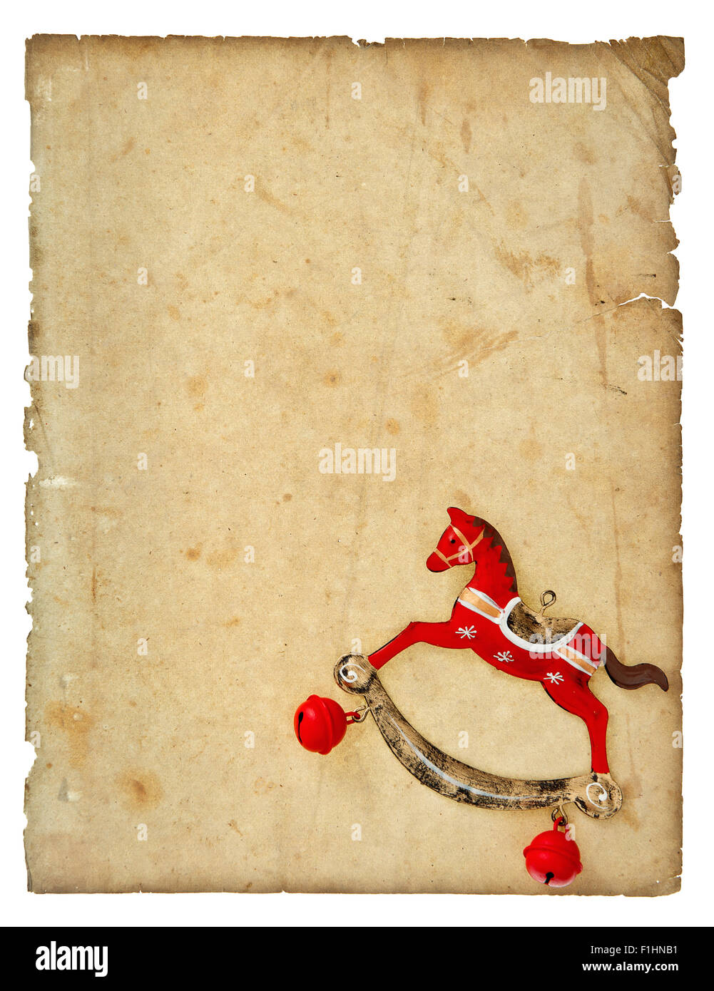 Christmas decoration vintage style rocking horse toy with aged paper page isolated on white background Stock Photo