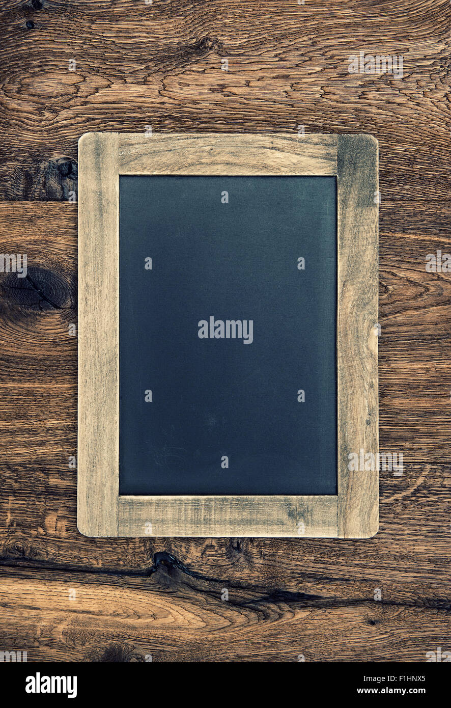 Vintage blackboard on wooden wall. Retro style toned chalkboard texture