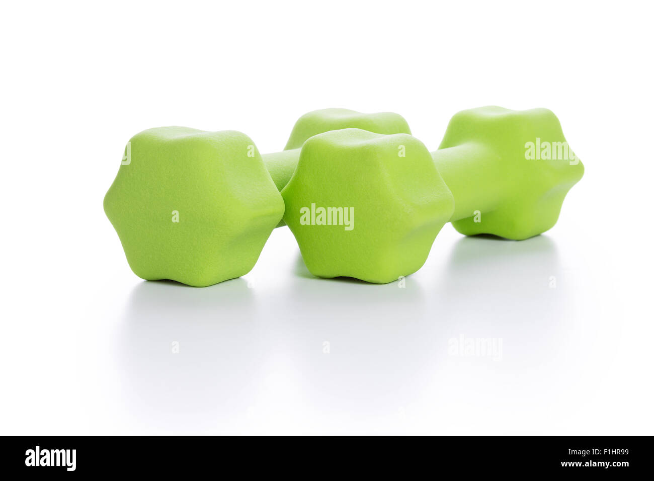 Fitness concept with two green dumbbells on white background, closeup Stock Photo