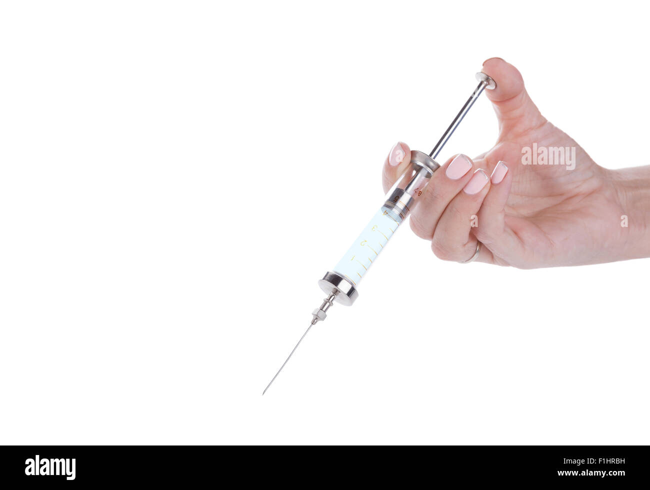 Old glass multiple use syringe in female hand, closeup on white background Stock Photo