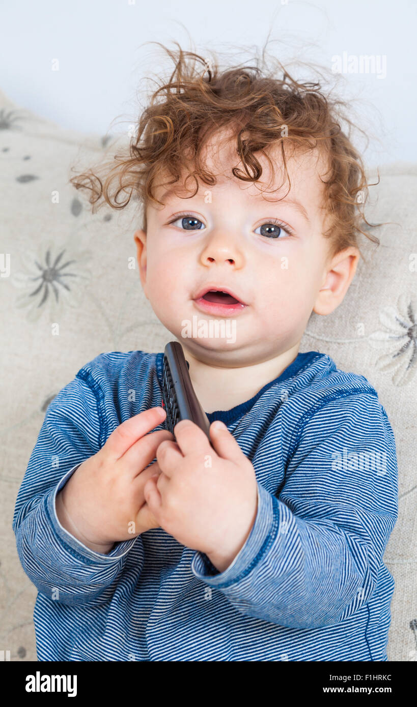 11 months old baby boy studing the tv remote control Stock Photo Alamy