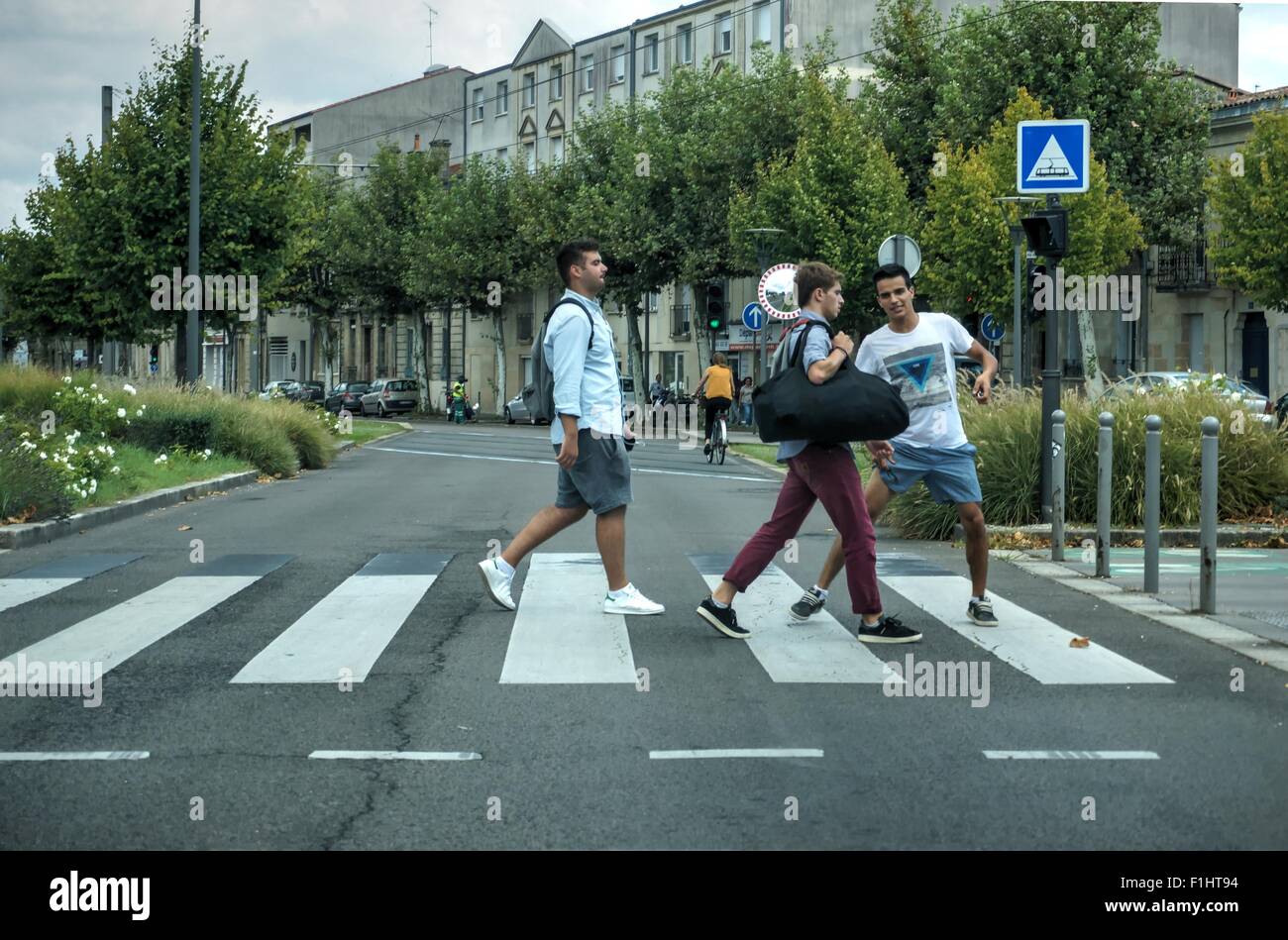 BORDEAUX, FRANCE, SEP 01,2015, Three high school students play and joke while crossing the street. Stock Photo