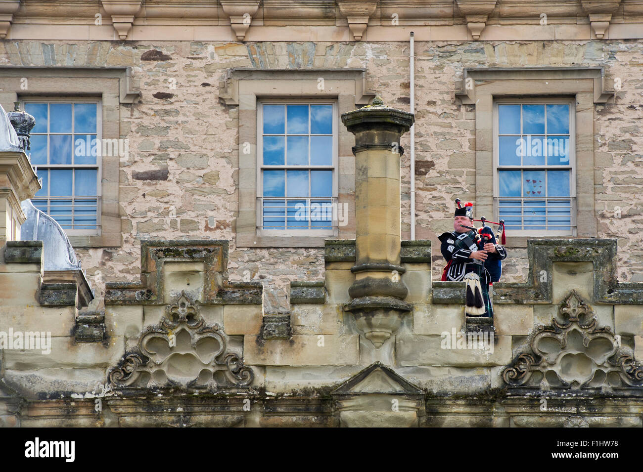 Lone Piper on the ramparts at Kelso Floors castle. Scotland Stock Photo