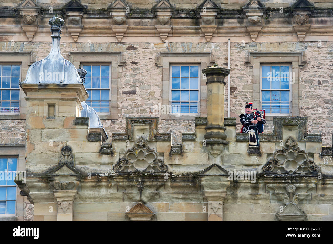 Lone Piper on the ramparts at Kelso Floors castle. Scotland Stock Photo