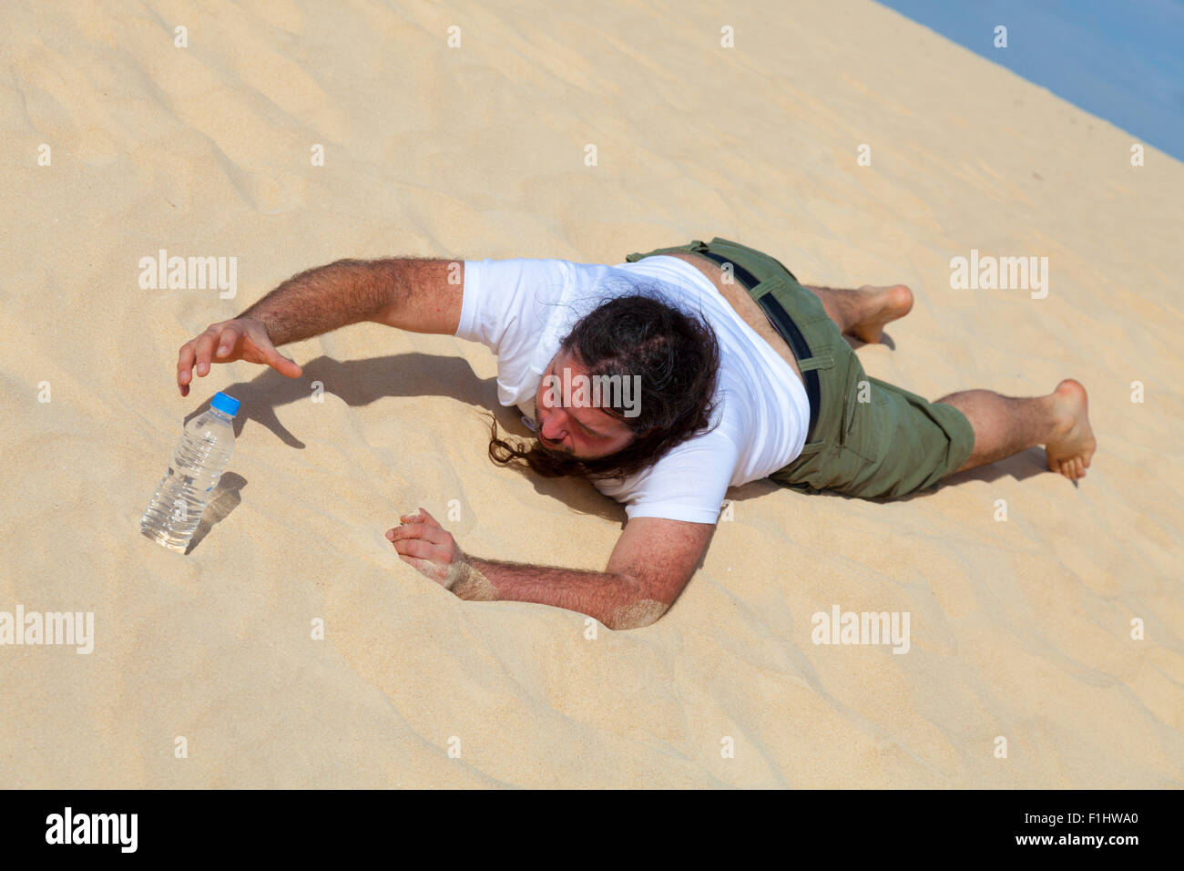 thirsty man reaches for a bottle of water in the empty Stock Photo