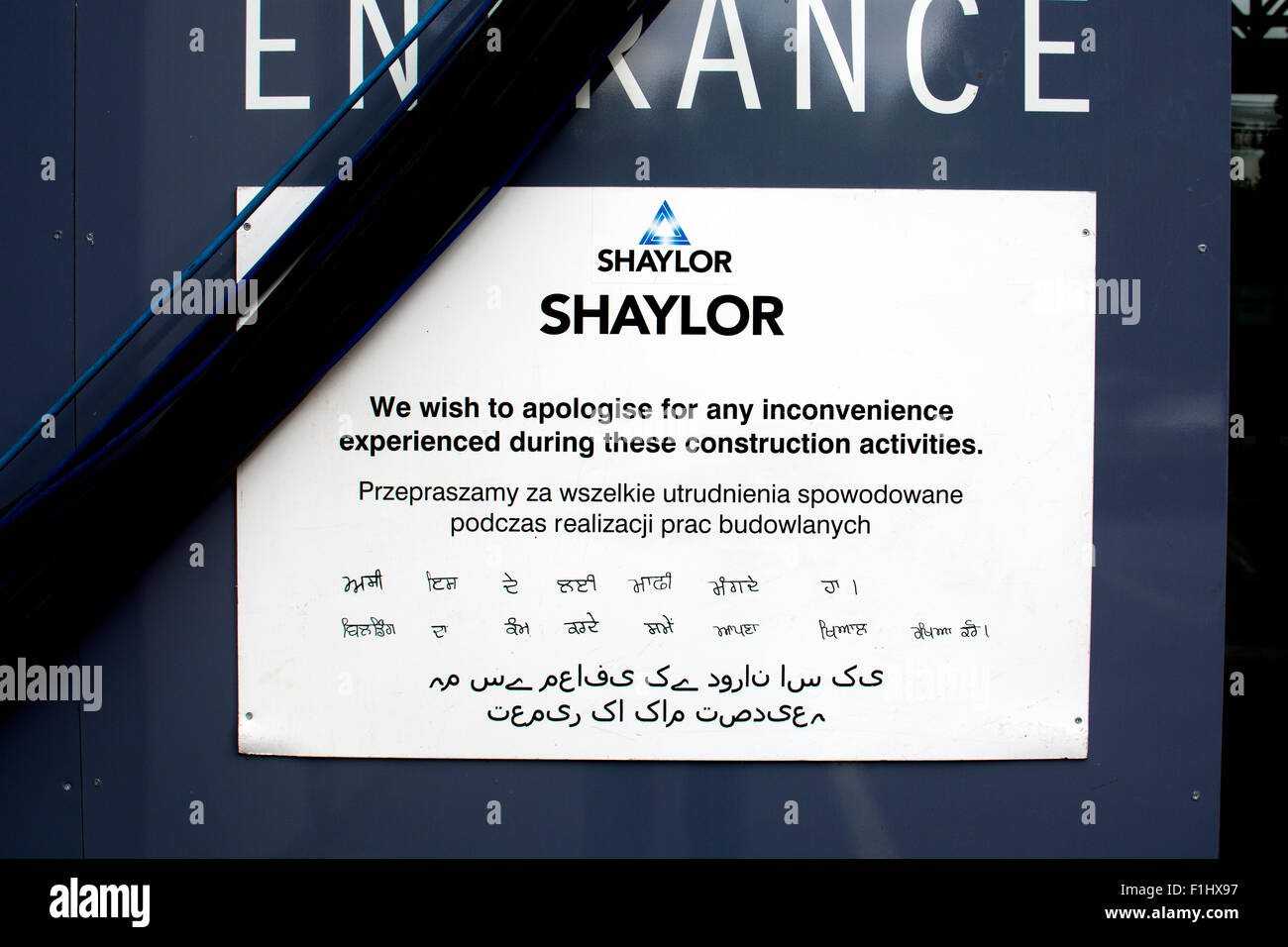 Multilingual sign on a Shaylor Group sign during the Swan Wing renovation, RSC Theatre, Stratford-upon-Avon, UK Stock Photo