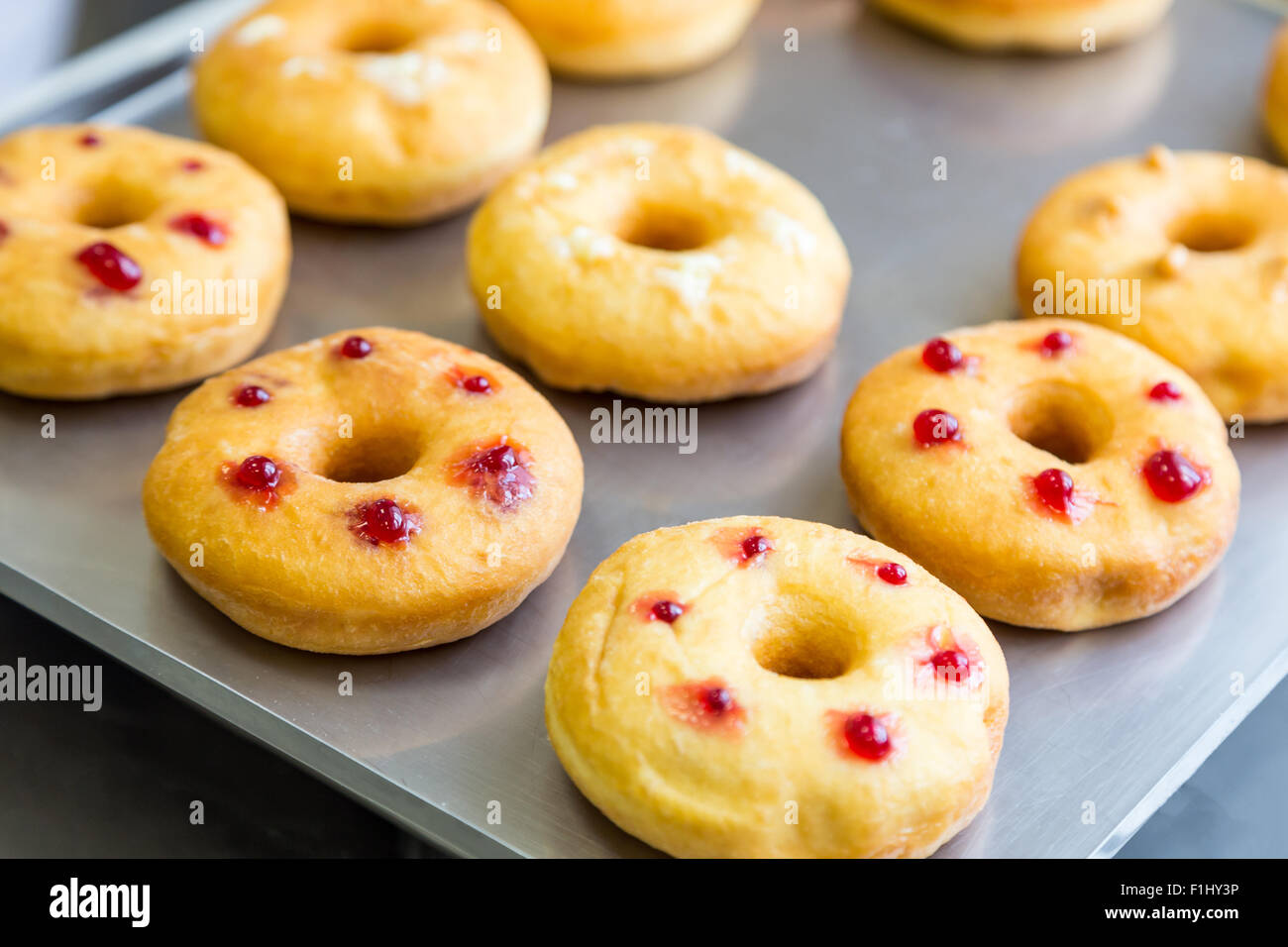 bakery doughnuts with assorted filling on metal tray Stock Photo