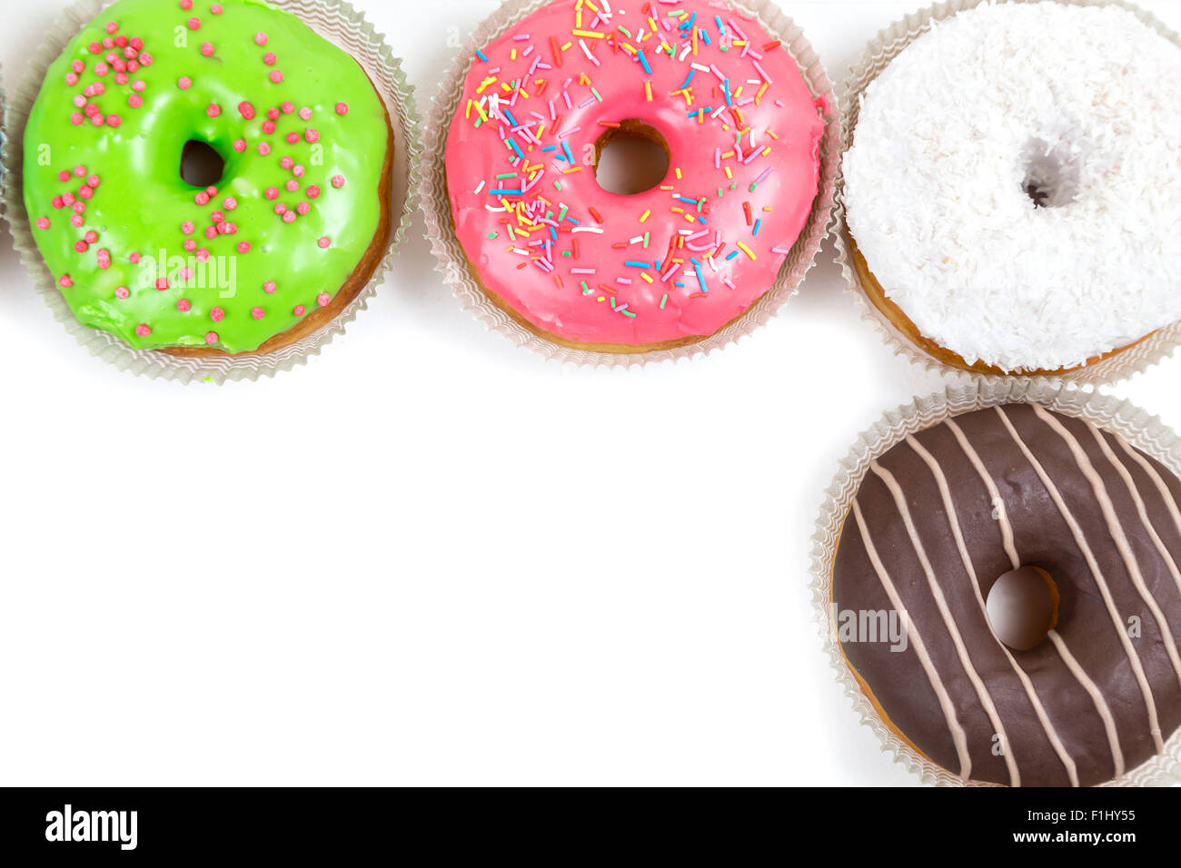 top frame from assorted glazed doughnuts in different colors on white ...