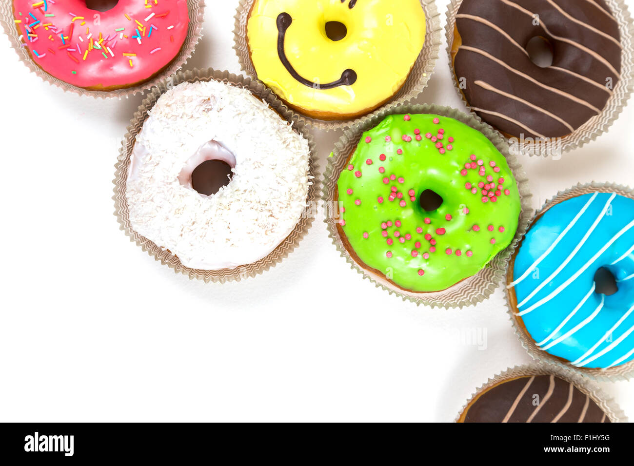 top frame from assorted glazed doughnuts in different colors on white ...