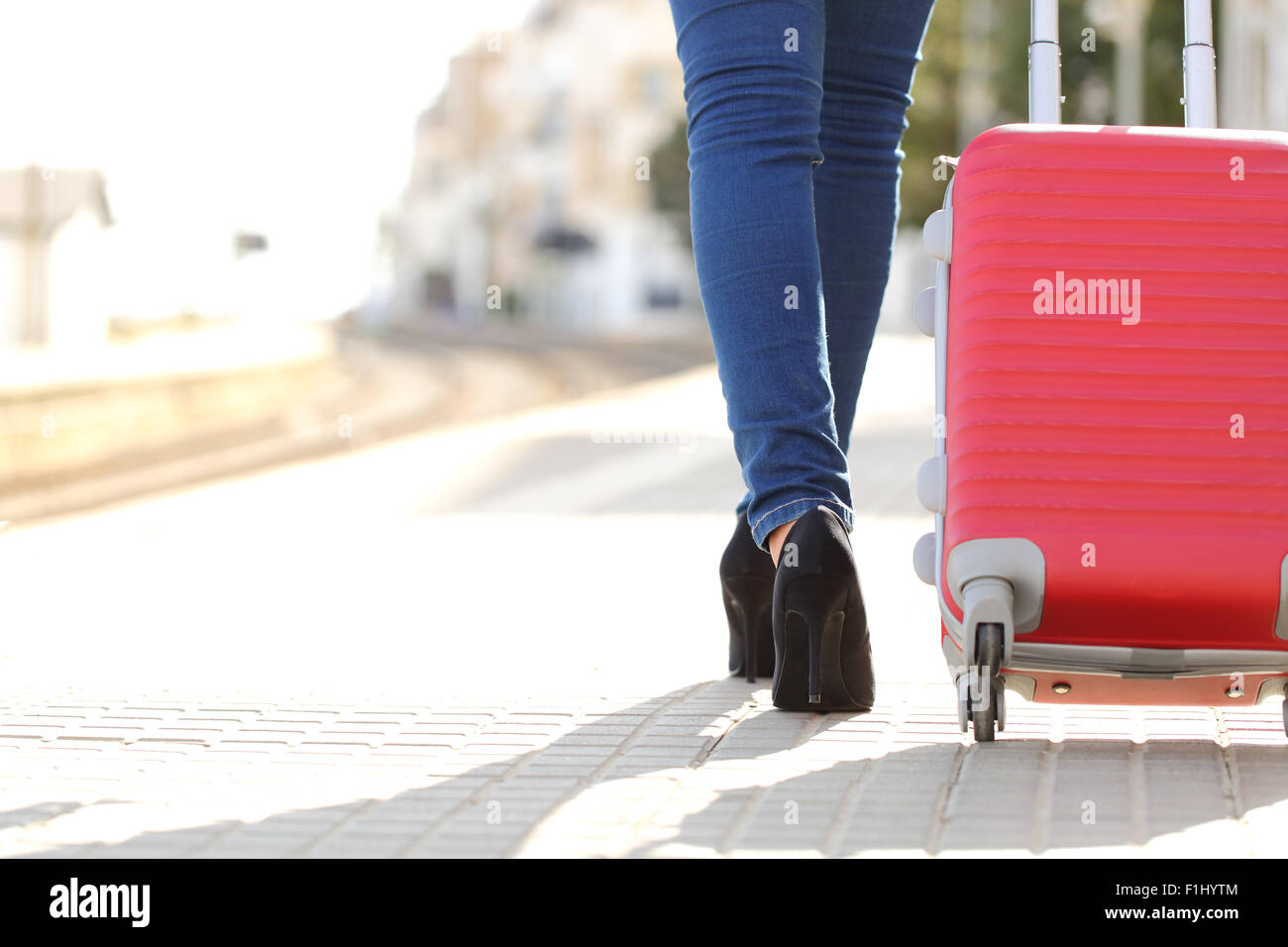 Traveler woman legs walking with luggage in a train station while she is waiting Stock Photo