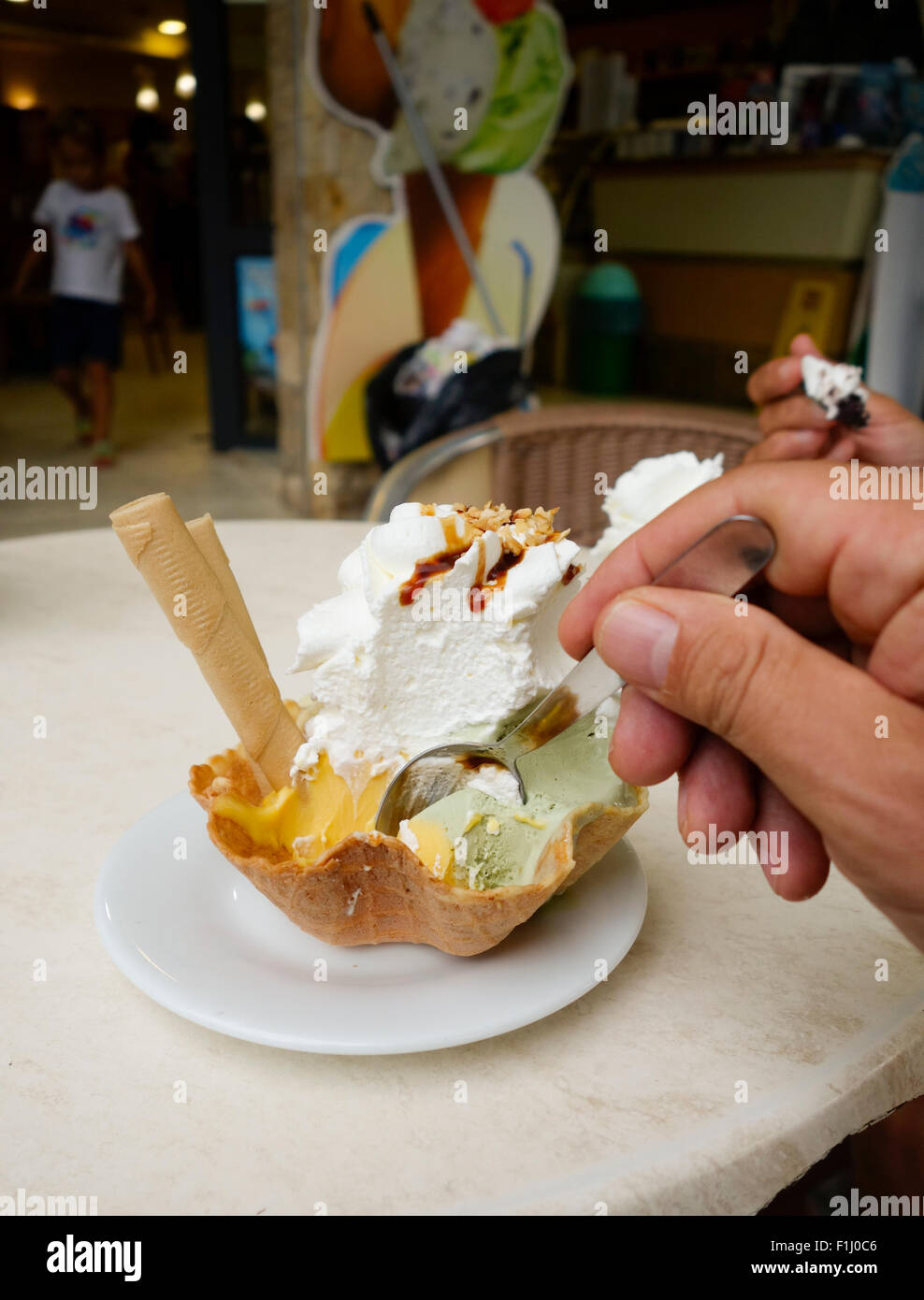 Hand with spoon reaching for waffle filled with Ice cream, Italian