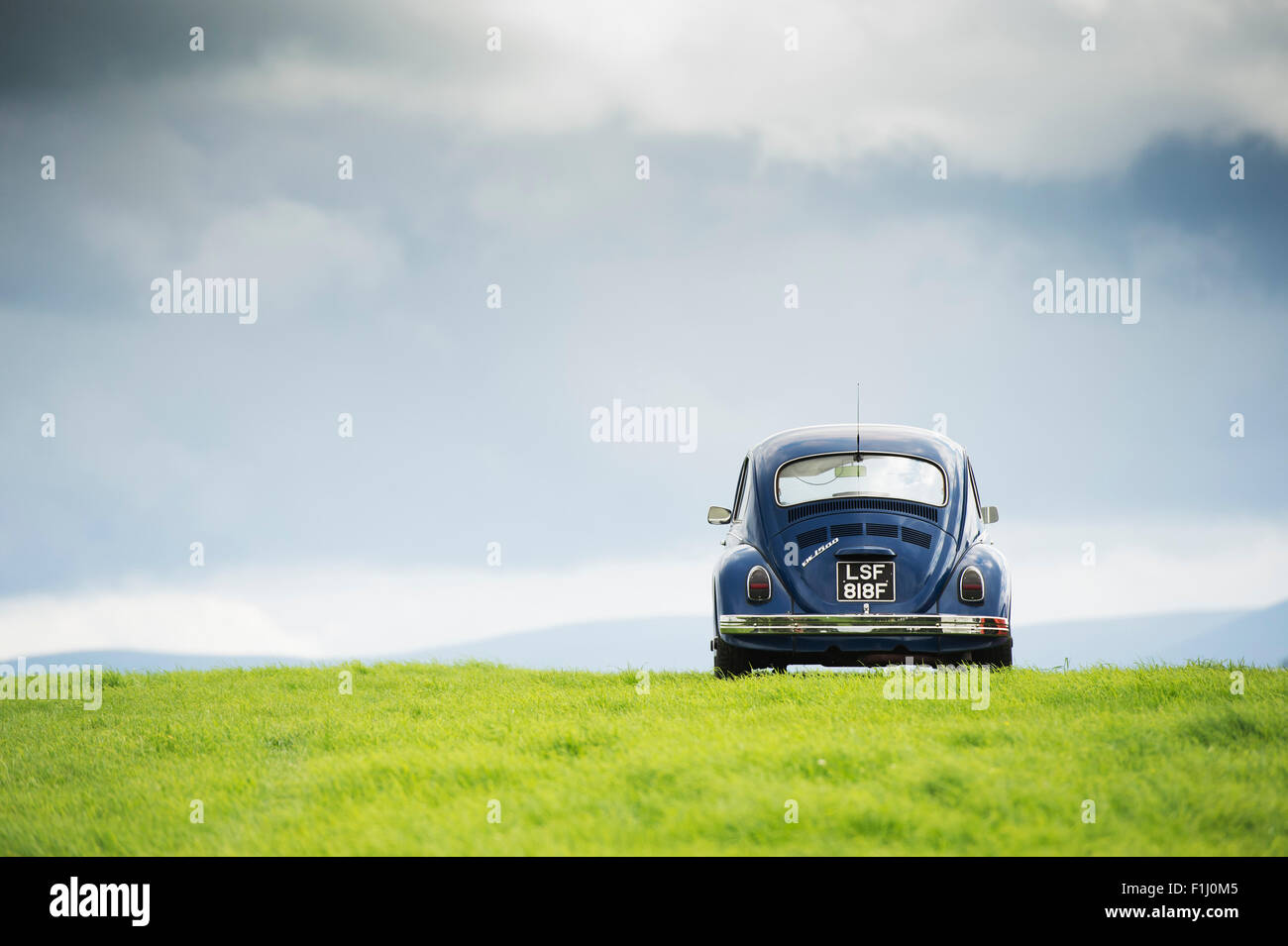 1968 VW Beetle car on a hill against a stormy sky in the scottish borders.  Scotland Stock Photo