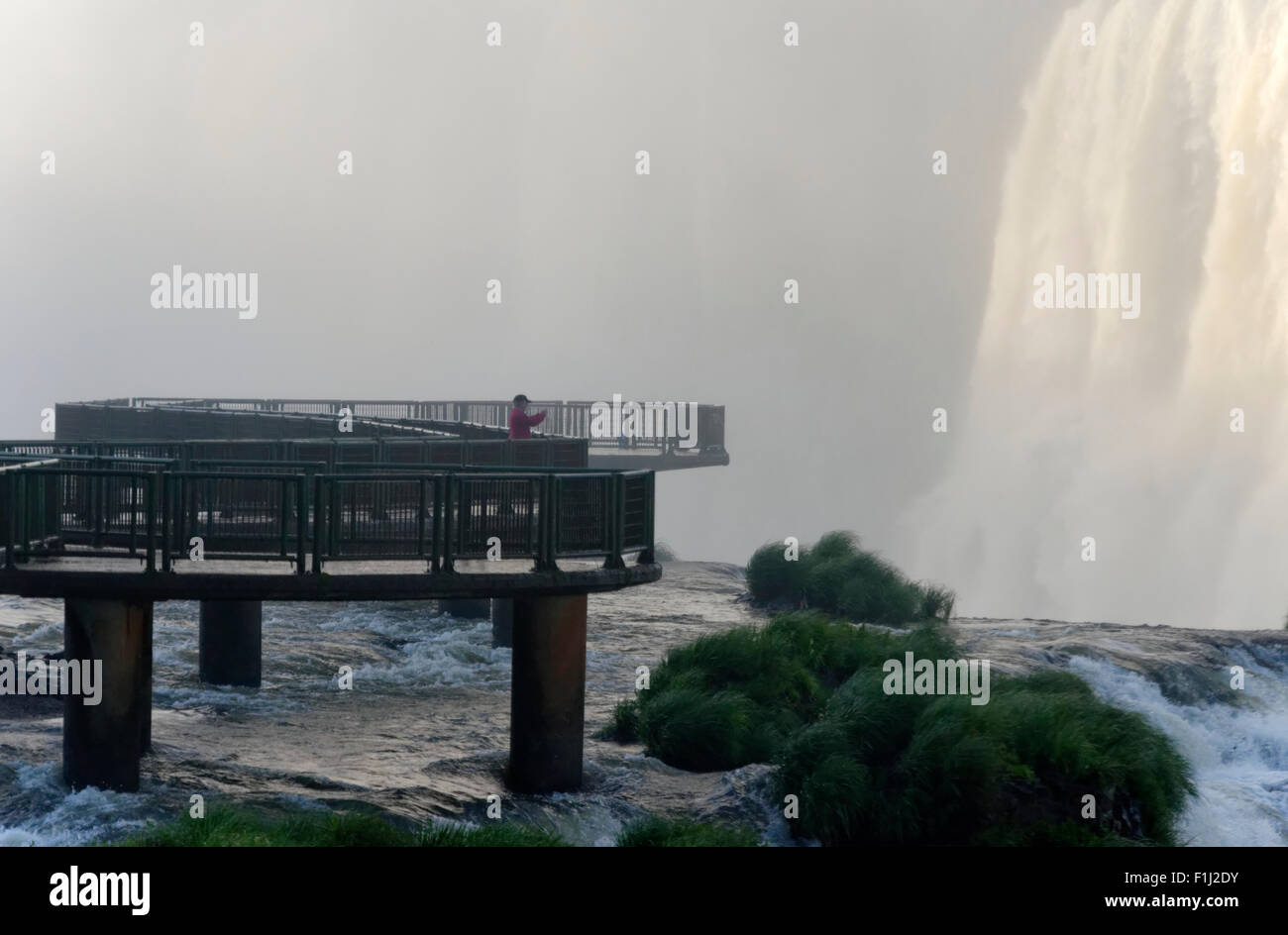 Sole person on the viewing platform over the waterfalls at Iguacu Falls, Brazil Stock Photo
