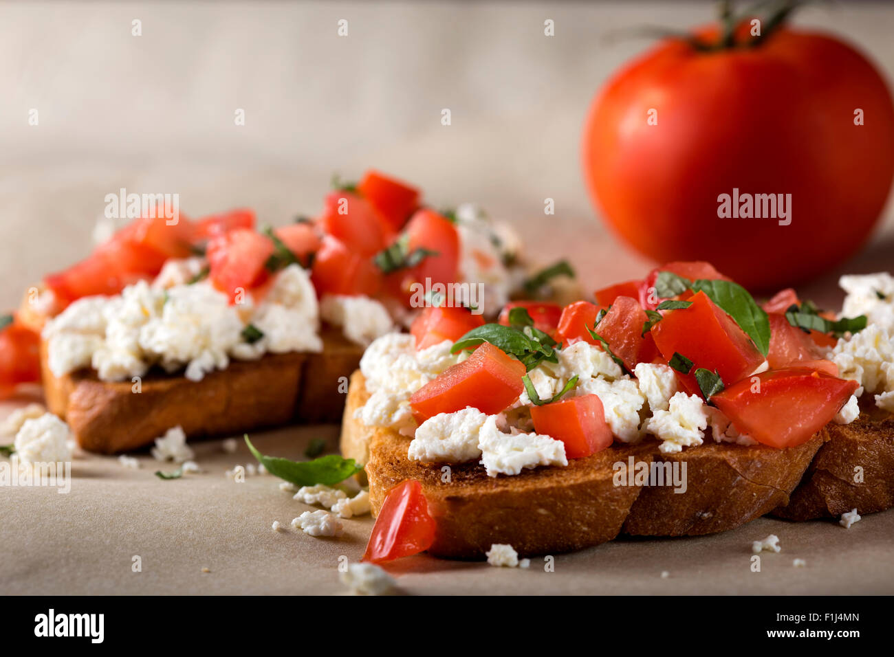 Italian Appetizer Bruschetta with roasted tomatoes, cheese and herbs Stock Photo