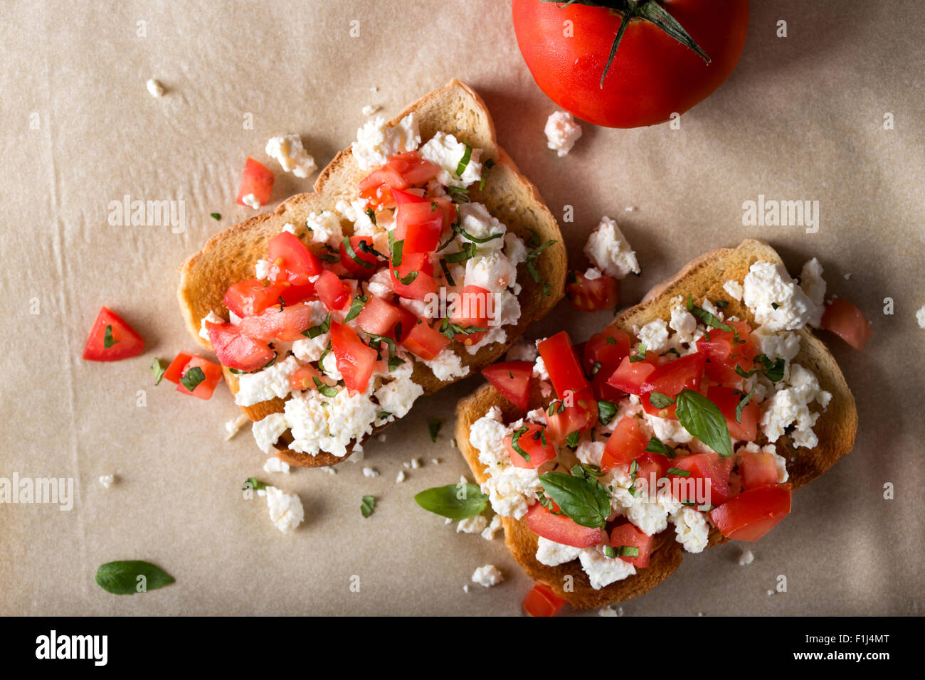 Italian Appetizer Bruschetta with roasted tomatoes, cheese and herbs Stock Photo