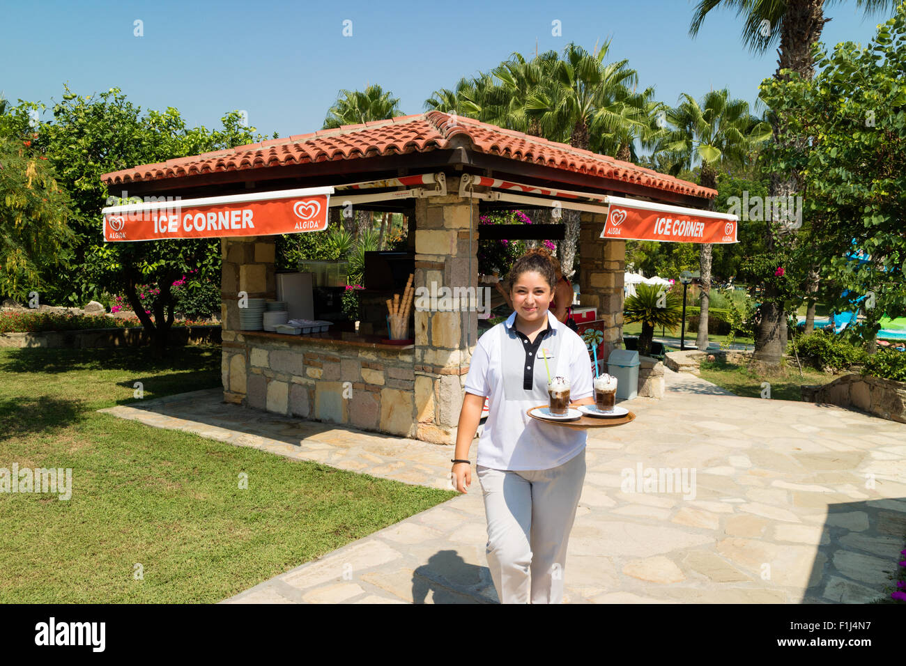 A waitress carries a tray of drinks at an ice-cream cafe Stock Photo