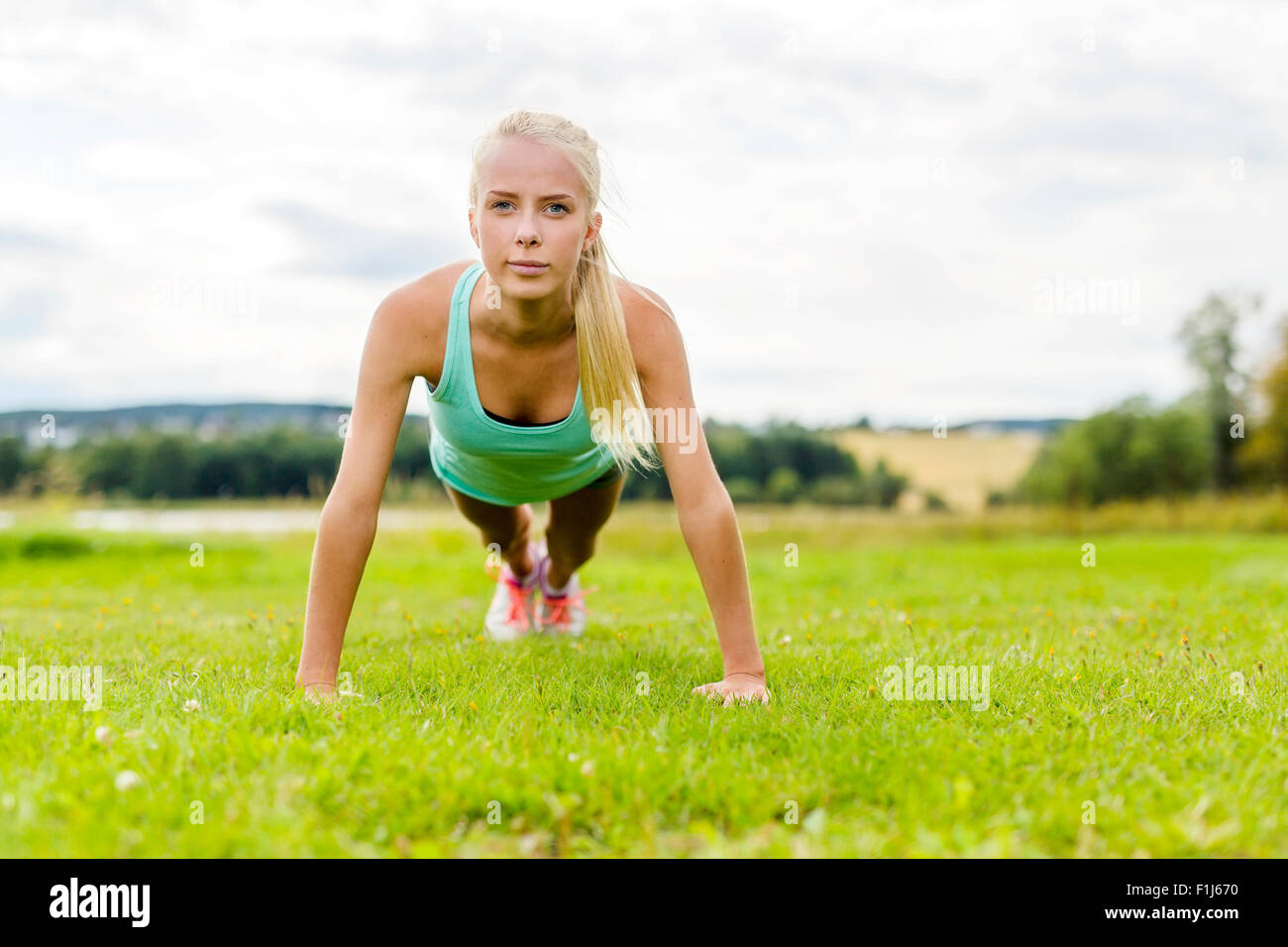 Young woman doing push-ups in the park Stock Photo