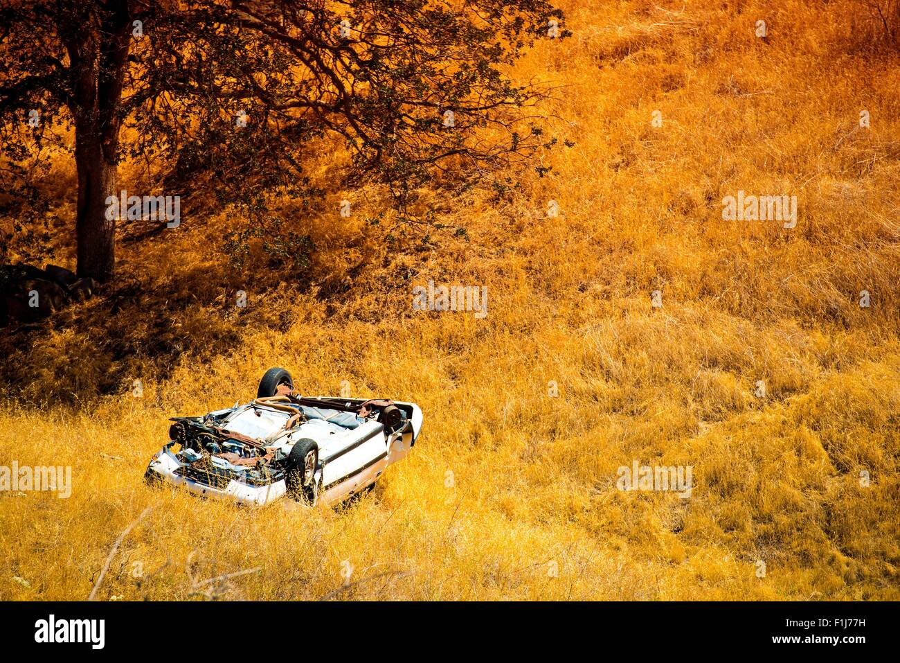 Rollover Compact Car Crash. White Crashed Car in the Mountain Road Ditch in California, USA. Traffic Accident. Stock Photo
