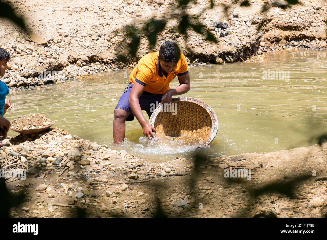 Illegal gem prospectors panning for gemstones in the gravel deposits of a river in Uva province, Sri Lanka. Stock Photo