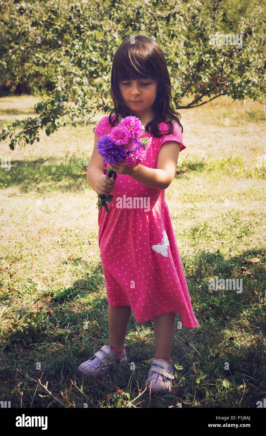 Little girl holding bouquet of field flowers Stock Photo - Alamy