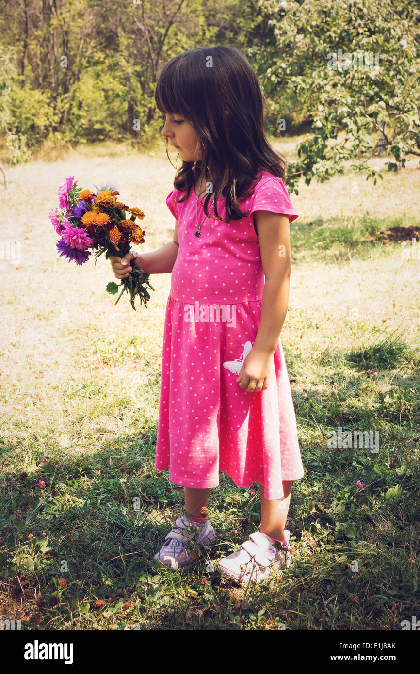 Little girl holding bouquet of field flowers Stock Photo - Alamy
