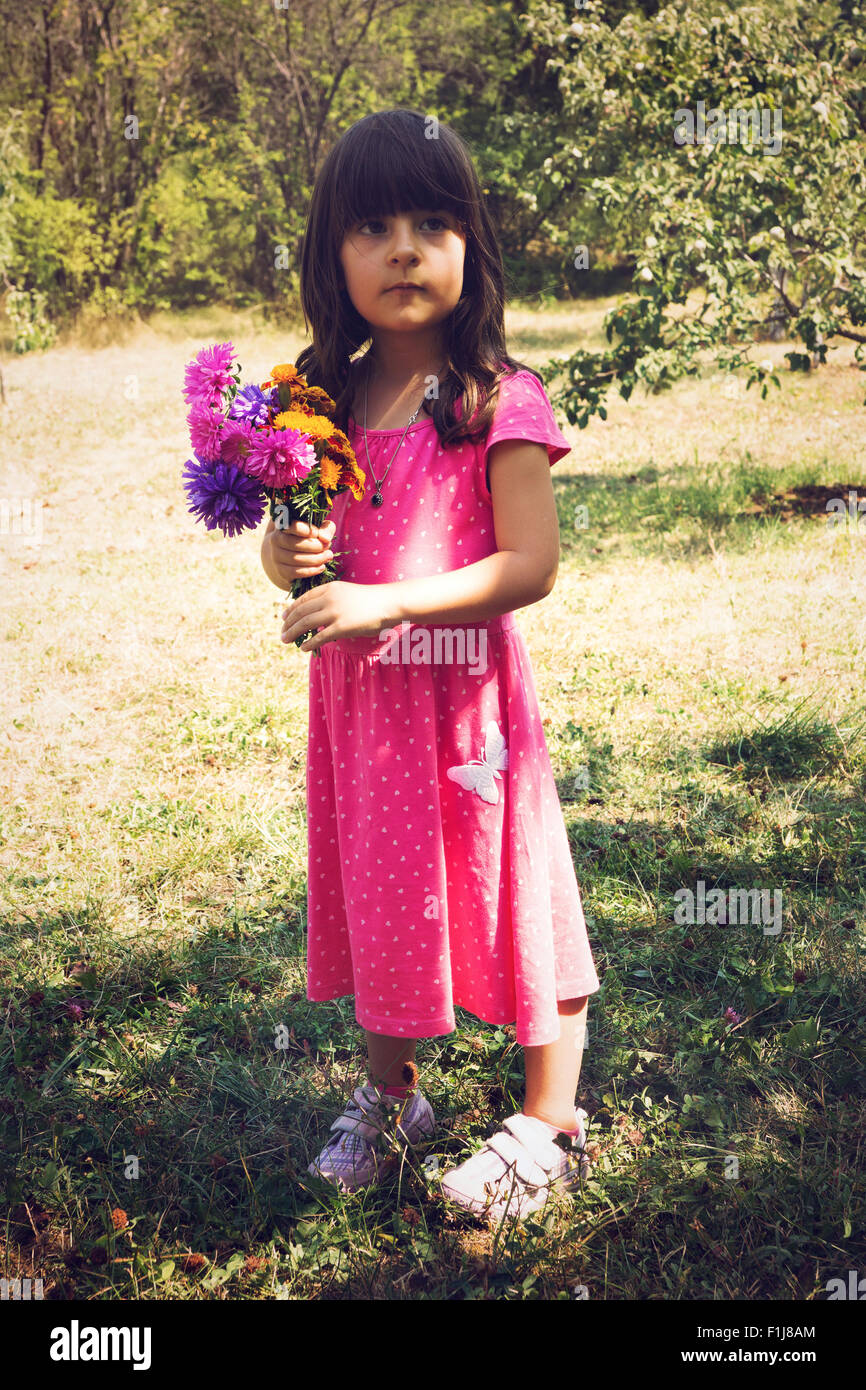 Little girl holding bouquet of field flowers Stock Photo - Alamy