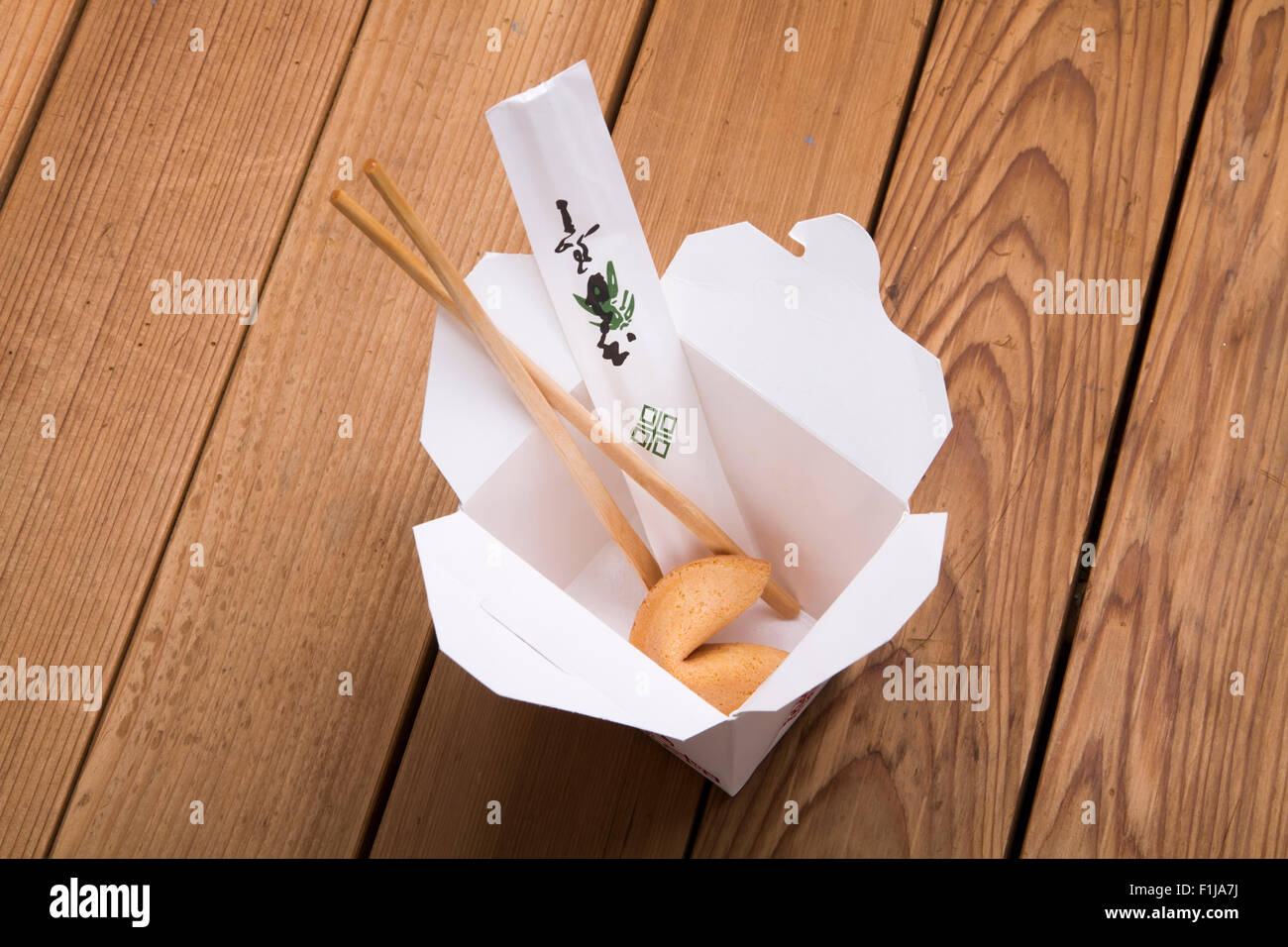 Chinese takeout carton on a wooden table with fortune cookie Stock Photo