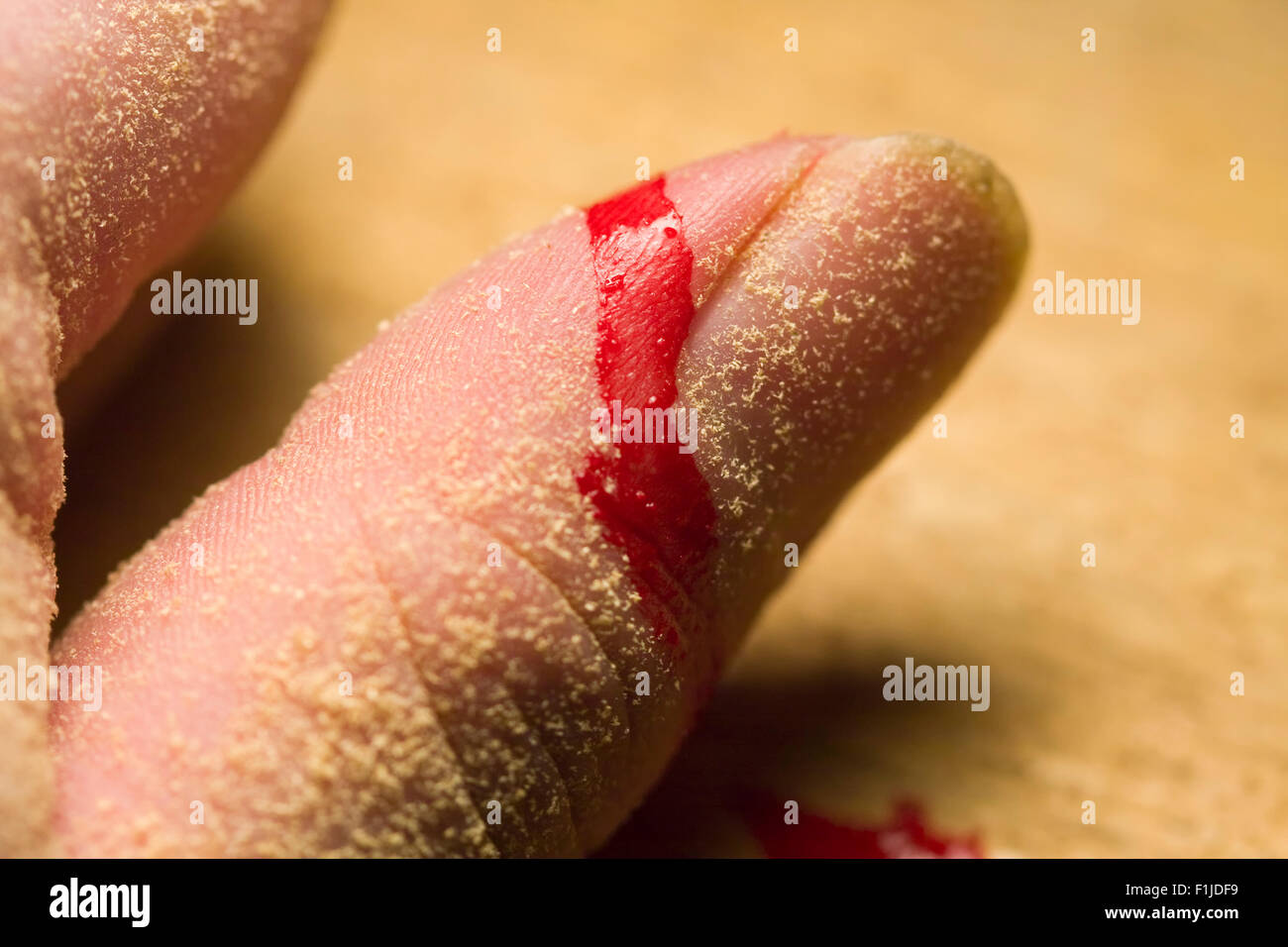 Thumb covered in sawdust and blood from a recent injury while woodworking Stock Photo