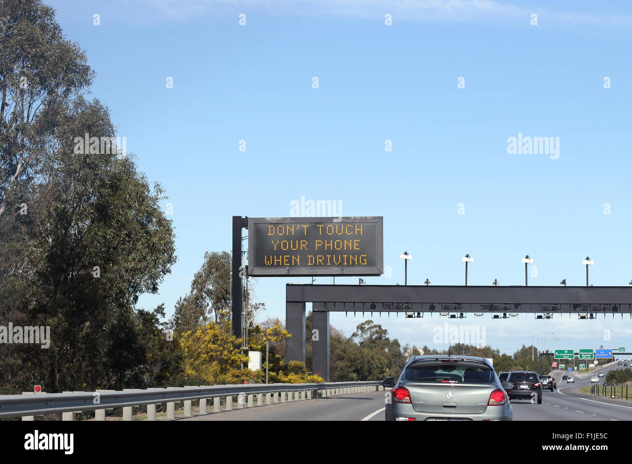 Safety reminder not to use mobile phone while driving on Melbourne Freeway Stock Photo