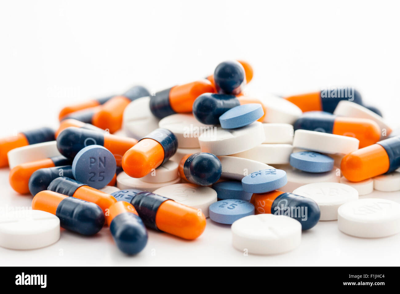 Medical drugs. Pile of Orange and blue capsules with blue and white
