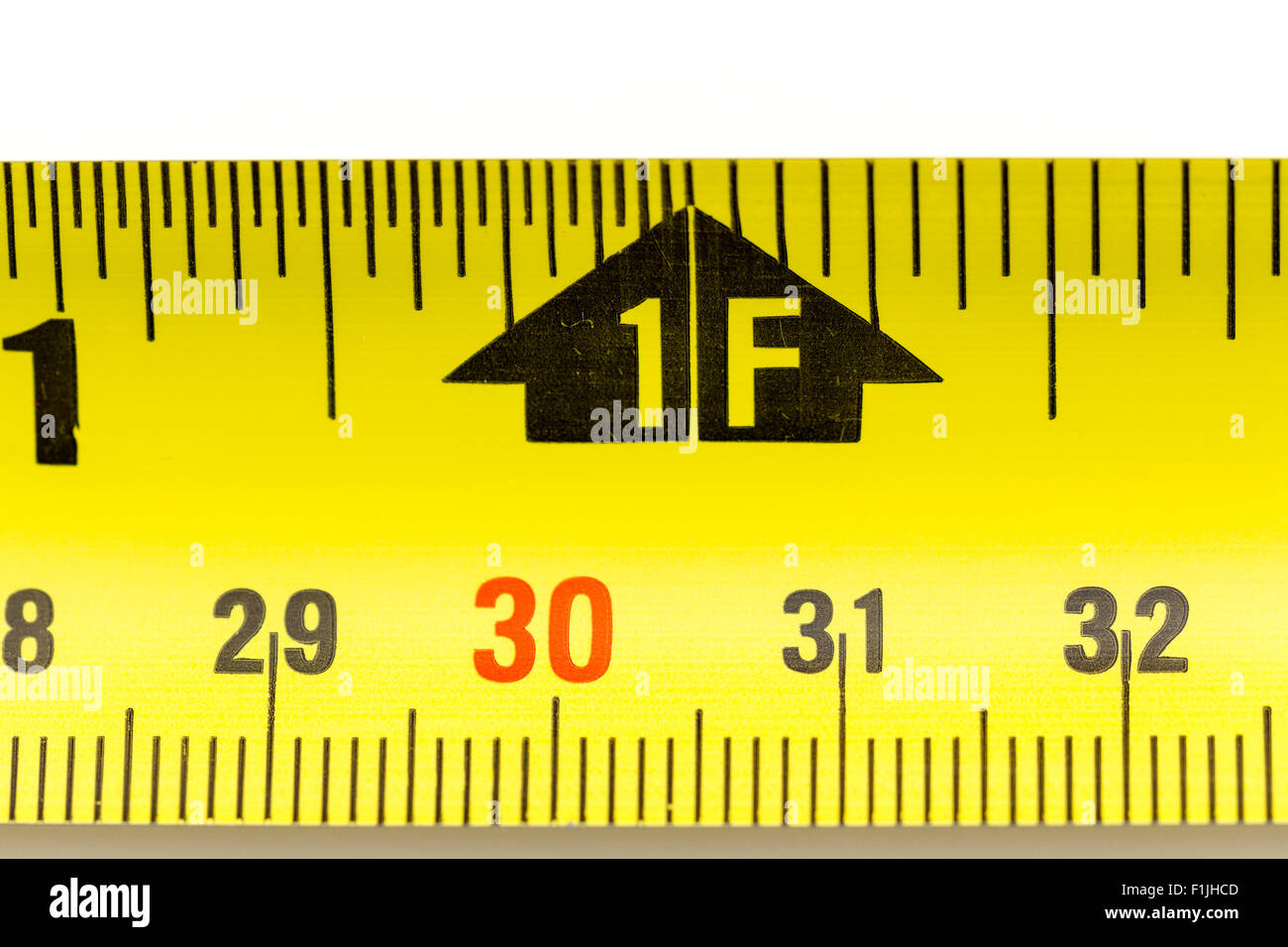 Rulers. Steel roller tape measure, 29-32cm and 1 ft with black arrow  marking. 30 centimeter marking in red. Close up Stock Photo - Alamy
