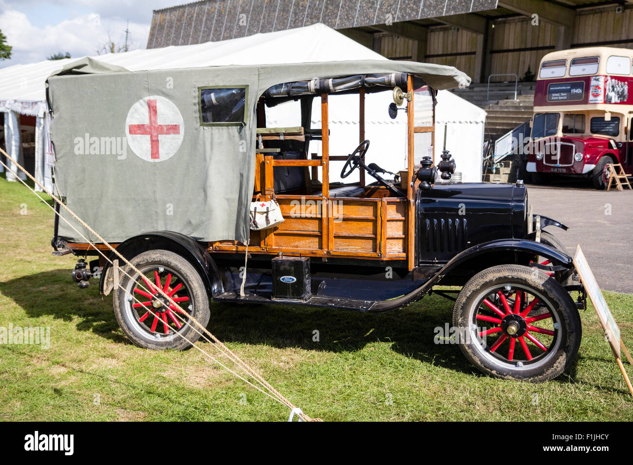 World War One vintage ambulance, a Ford model T, parked on grass with tents around with display board in front. Stock Photo