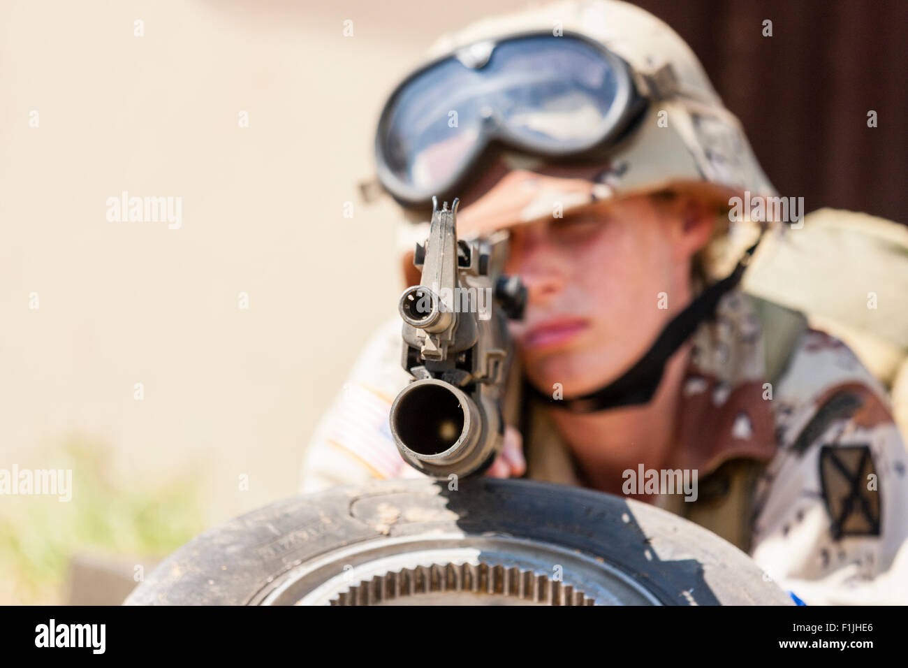 American army, black Hawk re-enactment, War and Peace show. Woman soldier laying down facing, aiming gun directly at viewer. Focus on gun muzzle. Stock Photo