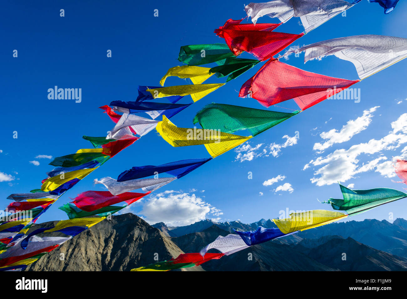 Tibetan prayer flags are wavin in the wind at Lamayuru Gompa, a monastery located in barren landscape, Lamayuru Stock Photo