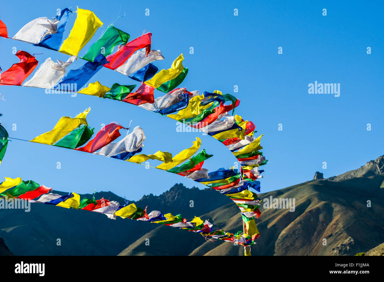 Tibetan prayer flags waving in the wind at Lamayuru Gompa, a monastery located in barren landscape, Lamayuru, Jammu and Kashmir Stock Photo