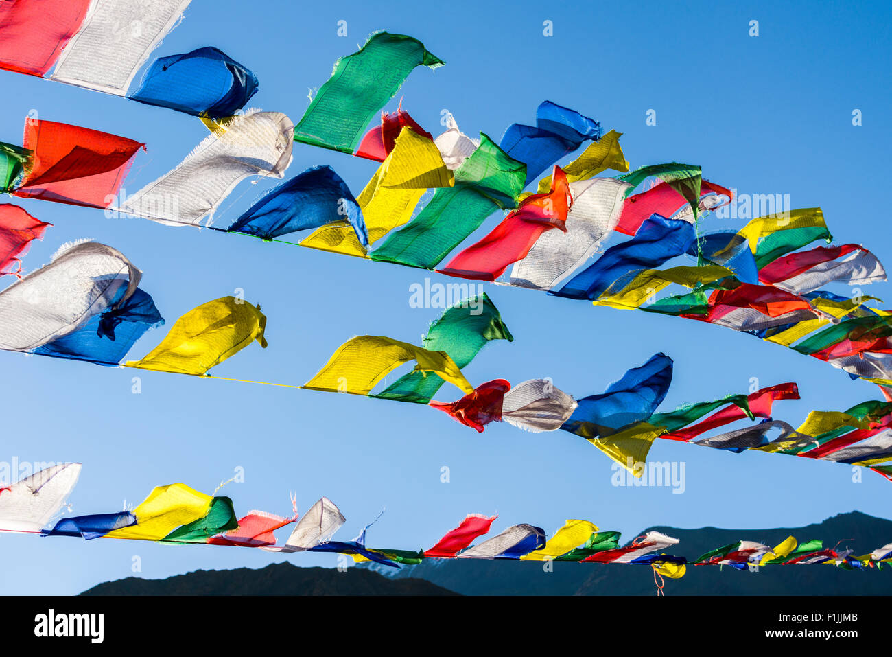 Tibetan prayer flags waving in the wind at Lamayuru Gompa, a monastery located in barren landscape, Lamayuru, Jammu and Kashmir Stock Photo