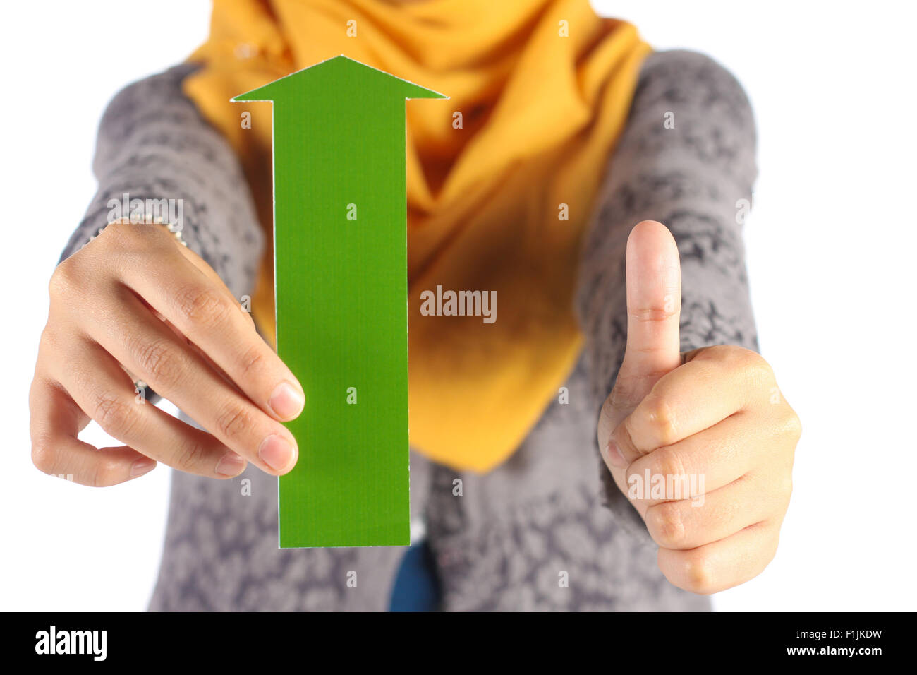 female hand holds green arrow and showing thumbs up sign Stock Photo