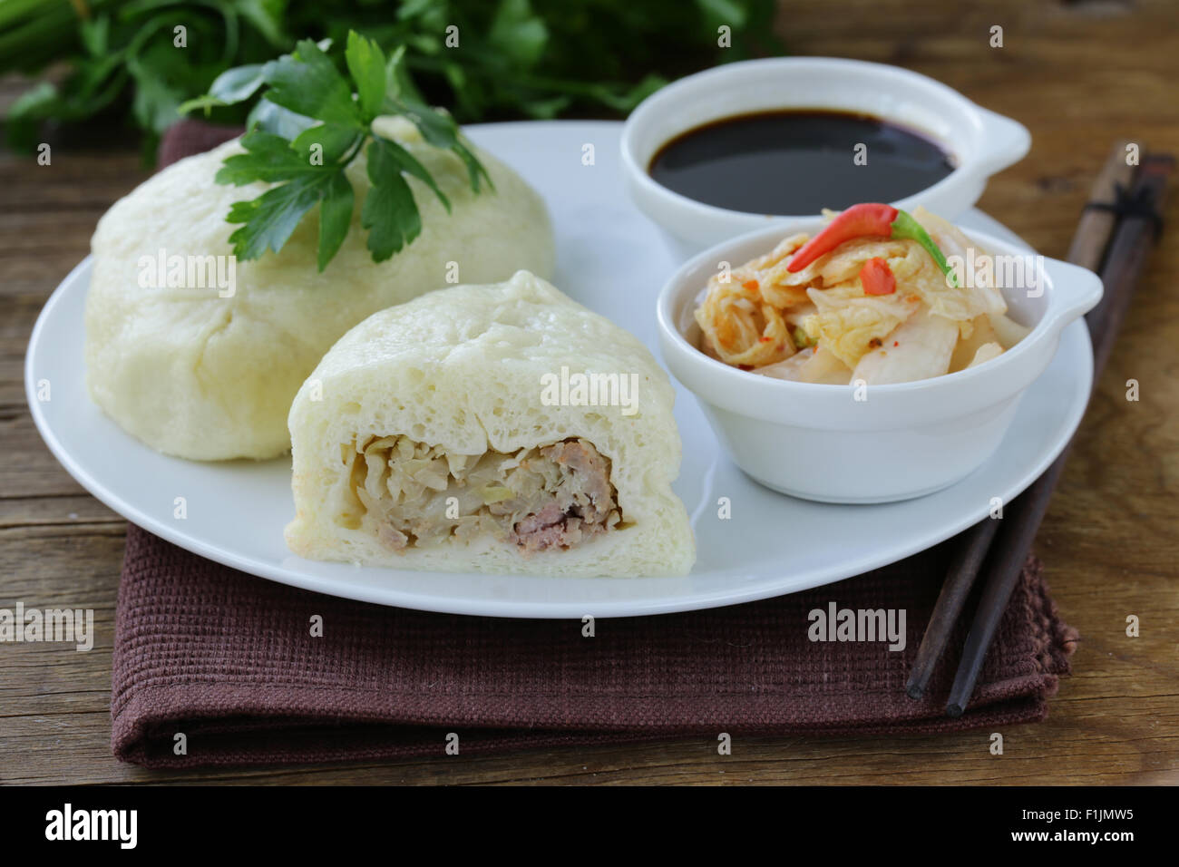 Korean steam meat pies (pigodi) served with soy sauce and kimchi Stock ...