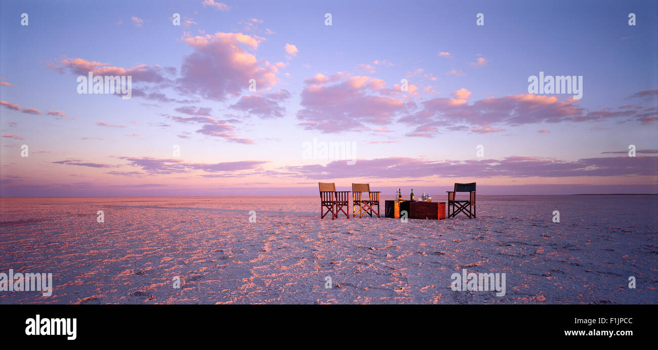 Table and Chairs in Desert at Sunset Kubu Island, Botswana, Africa Stock Photo
